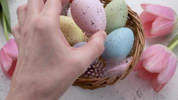 un' donna di mano mette un' colorato Pasqua uovo su il tavolo. video