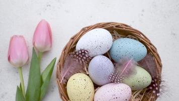 A woman's hand puts a basket with painted Easter eggs on the table. video
