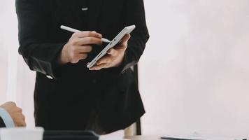 Financial analysts analyze business financial reports on a digital tablet planning investment project during a discussion at a meeting of corporate showing the results of their successful teamwork. video