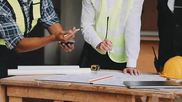 arquitecto hombre trabajando con ordenador portátil y planos, ingeniero inspección en lugar de trabajo para arquitectónico plan, bosquejo un construcción proyecto ,selectivo foco,negocio concepto Clásico color video