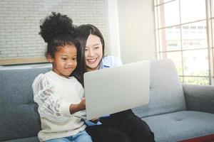 joven asiático hembra profesor tutoría a africano americano hembra estudiantes a hogar. durante el coronavirus desparramar. concepto de educación hogar estudiar foto