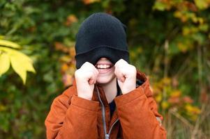 The smile of a child under a hat on his face photo