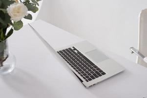 Grey laptop on a white desk open photo