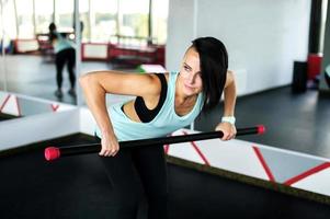 An athletic girl stands in the gym and shows exercises for group fitness photo