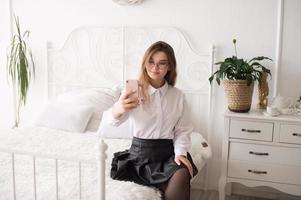 A happy woman has a video call. The girl looks into the phone camera and smiles. photo