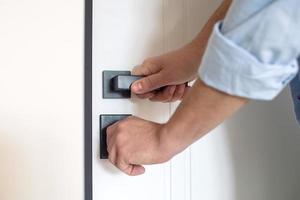 Men's hands open the door lock in the house photo