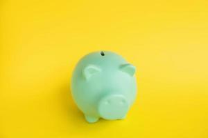 Blue piggy bank in the form of a pig on a yellow background photo