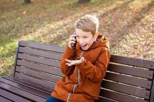 Emotional boy talking on the phone and laughing photo
