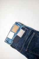 Two pairs of denim trousers in different colors with an empty leather label . photo