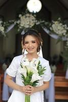 the bride with braces teeth and flower in hand with flower decoration wedding background photo