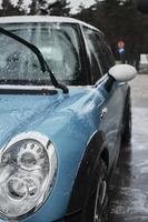 Hand wash with soap, pink foam on the body. Car washing with high pressure water. Wash Mini Cooper. photo