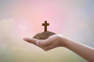 hand holdig cross  on bokeh background. photo