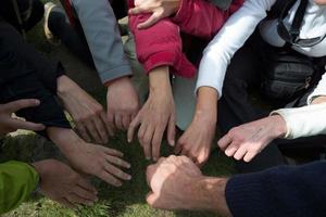 Approaching hands of a  group of friends with mountain clothes photo