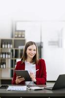 Woman freelancer is working her job on computer tablet and laptop Doing accounting analysis report real estate investment data, Financial at office photo