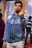 New Delhi, India - December 04 2022 - Unidentified people showing their ink-marked fingers after casting votes in front of polling booth of east Delhi area for MCD local body Elections 2022 photo