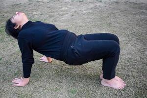 Young Indian woman practicing yoga outdoor in a park. Beautiful girl practice basic yoga pose. Calmness and relax, female happiness. Basic Yoga poses outdoor photo