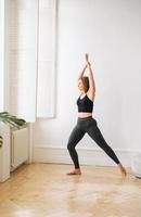 joven mujer delgada en ropa deportiva haciendo ejercicios de fitness, chica bailando en un estudio brillante foto