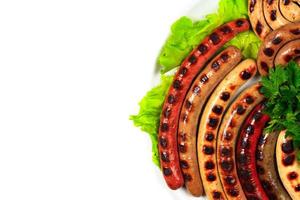 Closeup shot of a dish full of grilled sausages, isolated on white background. Flat lay photo