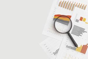 Business graphs, charts and magnifying glass on table. Financial development, Banking Account, Statistics photo
