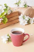 Cup of coffee and blossom apple twigs with vinage books. Springtime still life composition photo