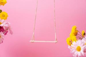 A swing with chrysanthemum flowers as a stand for your cosmetic product photo