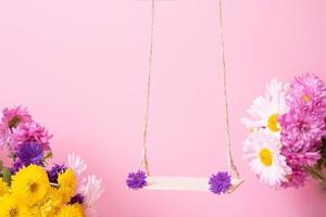 A swing with chrysanthemum flowers as a stand for your cosmetic product photo