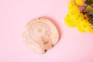 Wooden podium or pedestal with chrysanthemum flowers top view. Mockup for your cosmetic products photo