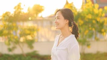 retrato joven hermosa asiático mujer con contento sonrisa alrededor al aire libre parque en soleado verano día foto