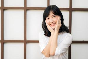 Portrait beautiful young asian woman happiness sitting on wooden grid wall, Happy female is smiling on wooden grid wall, wellness people concept. photo