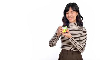 Asian woman holding a puzzle cube standing on white background. solving cubic problems, problem solution and making strategic moves concept photo