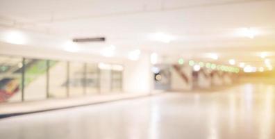 Blur image of empty car park in basement of garage shopping mall. Defocused interior background concept photo