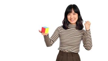 Asian woman holding a puzzle cube standing on white background. solving cubic problems, problem solution and making strategic moves concept photo