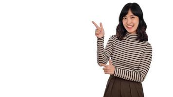 Beautiful young Asian woman on sweater cloth pointing up to copy space and looking at camera with smile face and happy isolated on white background photo