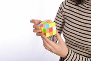 female hands holding a puzzle cube standing on white background photo