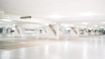 Blur image of empty car park in basement of garage shopping mall. Defocused interior background concept photo