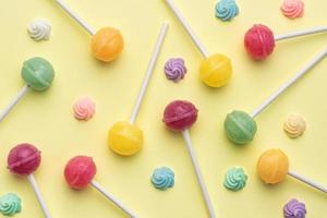 Sweet lollipops and candies on yellow background photo