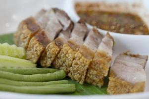 Deep-fried pork belly on a plate with fresh greens photo