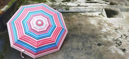 colorful patterned umbrellas in the yard after rain. rainbow umbrella. natural background. colorful umbrella, symbol of rainy weather season. copy space. banner photo