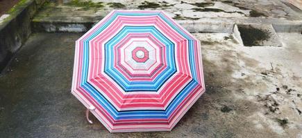 colorful patterned umbrellas in the yard after rain. rainbow umbrella. natural background. colorful umbrella, symbol of rainy weather season. copy space. banner photo