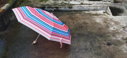 colorful patterned umbrellas in the yard after rain. rainbow umbrella. natural background. colorful umbrella, symbol of rainy weather season. copy space. banner photo