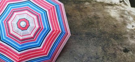 colorful patterned umbrellas in the yard after rain. rainbow umbrella. natural background. colorful umbrella, symbol of rainy weather season. copy space. banner photo