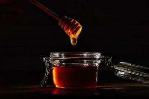 Honey with a natural wooden stick photo