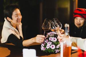 Happy family holding wine glasses toasting at dinner table. photo