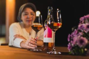 mujer mano participación vino vaso en cena mesa en el restaurante. foto