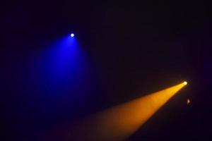 Orange beams of light from stage spotlights on a dark blue background.Illumination of the stage. photo