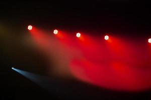 rojo etapa ligero desde focos en un oscuro antecedentes. foto