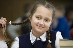 retrato de un de edad mediana Chica de escuela con gracioso trenzas foto