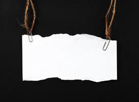 blank ripped paper hanging on rope photo