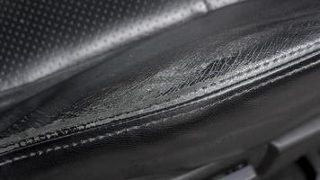 Surface of the leather seat is broken from long use. car seat angle inside car. photo