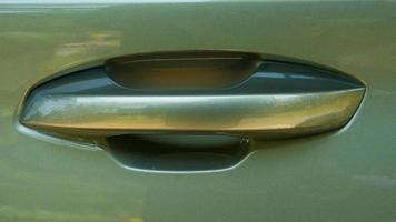 Beautiful car door opener handle. On the glossy green car floor. photo